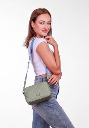 Zelená prošívaná crossbody taška s hladkým povrchem a kontrastním modro-růžovým pruhovaným popruhem. Kovové detaily na popruhu.