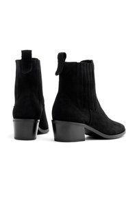 Czarne zamszowe botki za kostkę z elastycznymi panelami bocznymi, górnymi uchwytami i szerokim obcasem. Teksturowana powierzchnia z przeszytym wykończeniem.