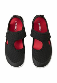 Zapatos infantiles negros con parte superior de malla transpirable, forro interior rojo, correa de velcro y suela de goma blanca. Patrones circulares en la tela.