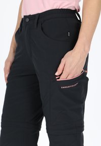 Black outdoor pants featuring a stretchy waistband, side pockets, and a zippered pocket with pink accents and logo detail.