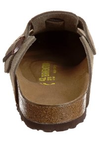 Sandal in suede marrone, con cinturino regolabile, soletta testurizzata e suola in gomma piatta. La fodera interna presenta il marchio del brand e la taglia.