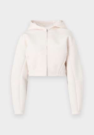 Skrócona bluza z kapturem w jasnoróżowym odcieniu z przednim zamkiem, z długimi rękawami i minimalistycznymi detalami szwów.