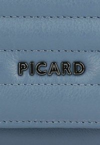 Light blue leather surface featuring stitched details and a black "PICARD" logo prominently displayed in the center. Smooth texture.