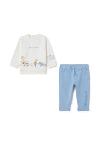 Witte sweatshirt met cartoonfiguren, met de tekst "volg je hart", gecombineerd met lichtblauwe sweatpants met een "Winnie the Pooh" print.