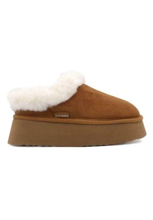 Pantofole in suede marrone con colletto in pelliccia sintetica bianca, suola piatta spessa e fondo testurizzato. Presenta un'etichetta laterale con il nome del marchio.