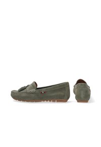Grüne Wildleder Slipper mit Quastenakzent, Gummisohle und einem kleinen rot, weiß und blauem Logo-Detail an der Seite. Glatte Textur und lässiges Design.