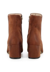 Bottes chelsea en cuir marron avec une texture lisse, bout rond, talon bloc de hauteur intermédiaire et zips latéraux pour un enfilage facile.