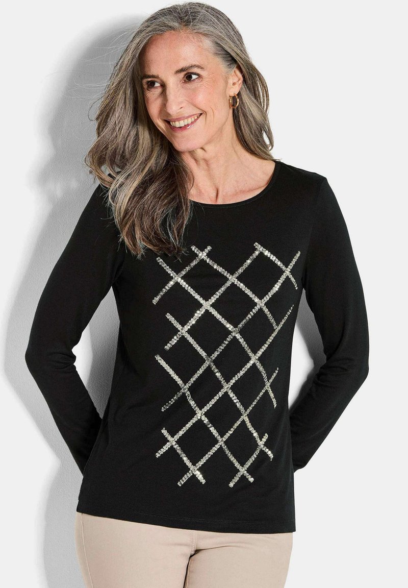 Schwarzes Langarmoberteil mit einem diamantförmigen Muster aus silbernen Pailletten auf der Vorderseite. Glattes Material mit einem klassischen Rundhalsausschnitt.