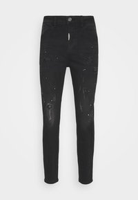 Černé džíny z denimu s úzkým střihem, které mají místa s poškozením, bílé skvrny od barvy, pět kapes a zapínání na knoflík a zip.