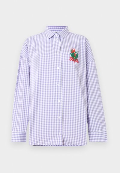 Πουκάμισο με κουμπιά σε λευκό και λιλά καρώ, μακριά μανίκια και κόκκινη κεντημένη floral διακόσμηση στο αριστερό στήθος με τη φράση «Stay late.»