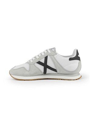 Zapatillas de ante gris y malla con acentos negros y suela de goma blanca. Presenta un cierre con cordones y un patrón texturizado en la parte superior.