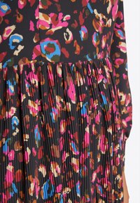 Skládané šaty s černým základem a živými, abstraktními květinovými vzory v růžových, modrých a hnědých odstínech. Vyrobeno z měkké tkaniny.