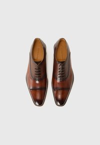 Zapatos de vestir de cuero marrón con punta afilada, acabado suave, sutil textura horizontal y cordones en la parte superior.