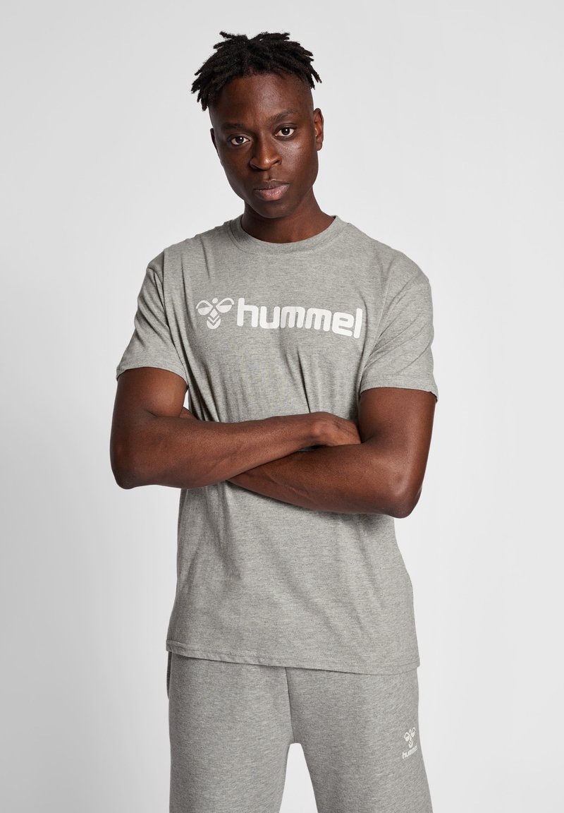 Grijze katoenen t-shirt met korte mouwen, met een witte "hummel" logo op de borst. Klassieke ronde hals, losse pasvorm, zachte textuur.