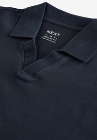 Mornarska polo majica s ovratnikom in v-izrezom. Narejena iz teksturirane tkanine, z oznako "NEXT M REGULAR FIT".