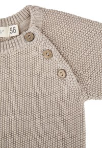 Beige gestrickter Babypullover mit drei Holzknöpfen schräg an der Schulter und ribbed Kragen, Größe 56.