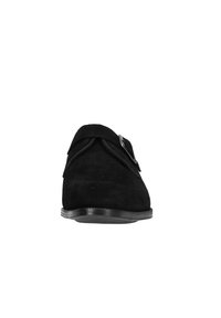 Black suede shoe featuring a rounded toe, a decorative fold at the front, and a metal buckle accent on the side. Flat rubber sole.
