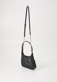 Sac à main en cuir noir avec une finition texturée, affichant un devant à motifs, une bandoulière réglable et un accent en chaîne argentée.
