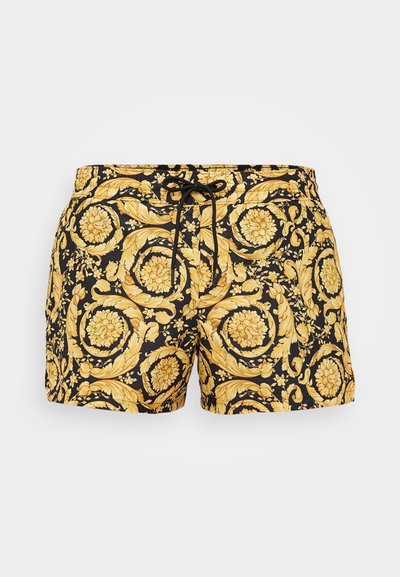 Schwarze Badeshorts mit einem kunstvollen gelben barocken Blumenmuster und einem schwarzen Kordelzug am Bund, dargestellt vor weißem Hintergrund.