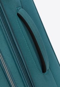 Uchwyt walizki w kolorze morskim z teksturowaną tkaniną, ergonomicznym uchwytem z czarną wkładką i gładkim zamkiem błyskawicznym po boku.