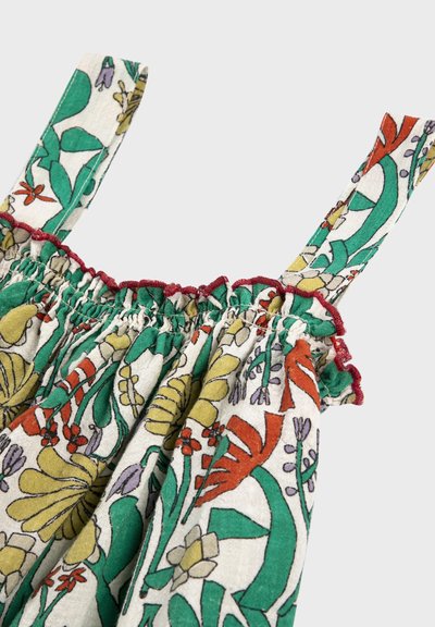 Vêtement sans manches avec bord supérieur froncé, présentant un motif floral multicolore en vert, jaune, orange, violet sur fond blanc et des coutures rouges.