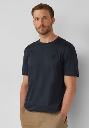 Navy blue katoenen t-shirt met een ronde hals en korte mouwen, voorzien van een klein zwart logo op de borst, een gladde textuur en een relaxte pasvorm.