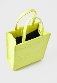 Majhna rumena usnjena torbica z dvema ročajema, z vloženim logotipom "DKNY", strukturirane oblike in notranjim predalom.