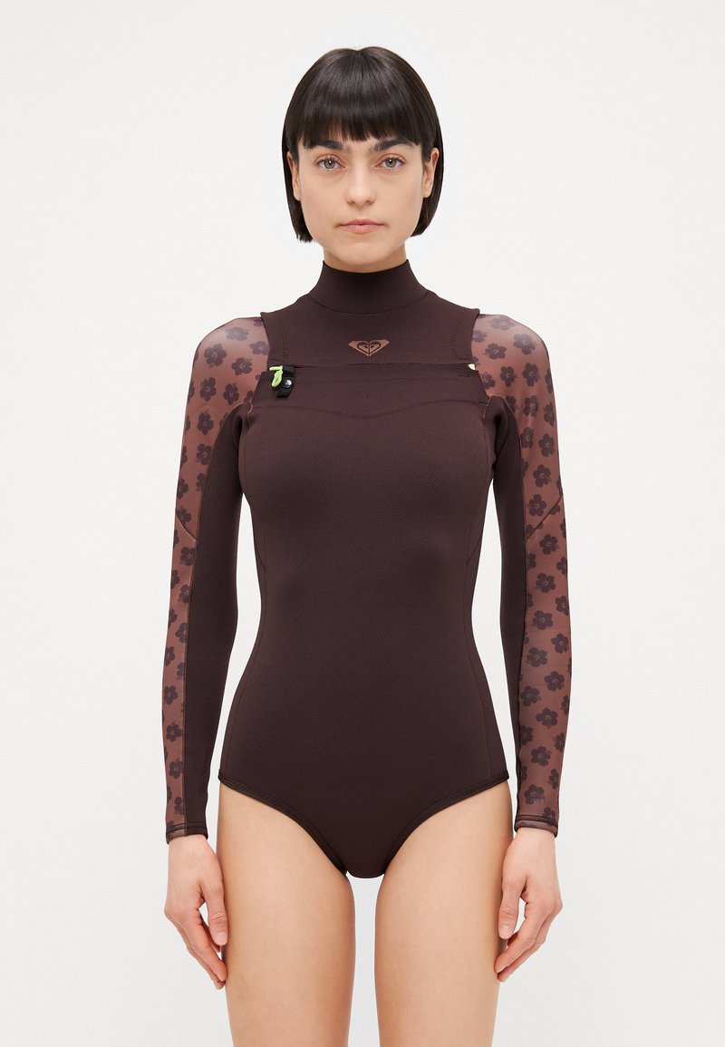 Costum de neopren lung, cu mâneci lungi, de culoare marron, cu un guler înalt, mâneci din plasă cu model floral și un logo pe piept. Textură netedă și design ajustat.