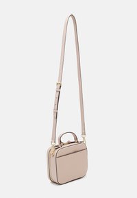 Sac à bandoulière en forme carrée fait en cuir beige clair, avec une poignée supérieure, une bandoulière réglable et des accents en métal doré.