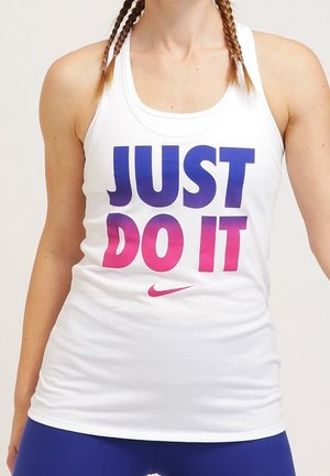 Débardeur blanc avec « JUST DO IT » en lettres dégradées bleu et rose, avec un petit logo Nike rose en dessous, porté par une personne aux cheveux tressés.