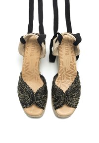Sandali neri con perline, con punta aperta, cinturini in tessuto intrecciato e dettaglio con incrocio. Presentano una soletta in pelle tan testurizzata.