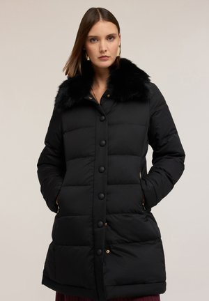 Schwarze gepolsterte Jacke mit einem Kragen aus Kunstfell, vorderem Knopfverschluss und Seitentaschen mit goldenen Hardware-Akzenten.