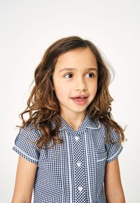 Granatowo-biała koszula w kratkę z krótkimi podwiniętymi rękawami, kołnierzykiem i guzikami w kształcie serca; posiada białe wykończenie z przodu.