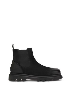 Botas Chelsea negras con un upper de cuero suave, paneles laterales elásticos, una lengüeta y una suela de goma gruesa con detalles de tracción.