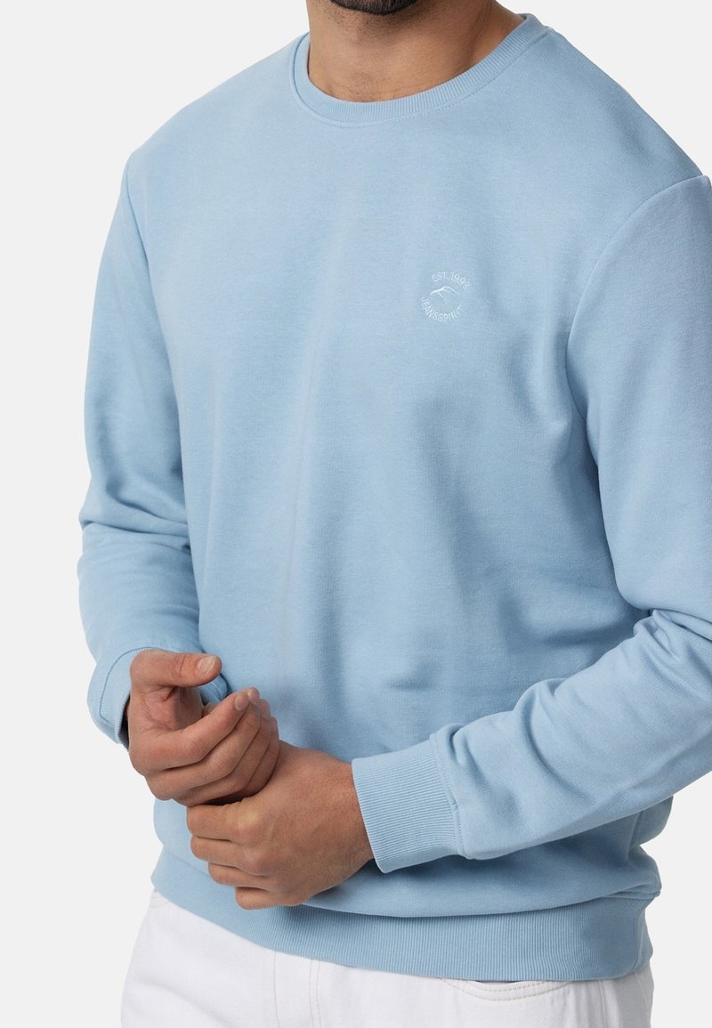 Lichtblauw crewneck sweatshirt van katoen, met ribgebreide boorden en zoom, en een klein wit logo op de linkerkant van de borst.