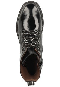 Černá kotníková bota z lesklé lakované kůže se šněrováním vpředu, kulatou špičkou a kontrastními šitými detaily. Vnitřek je podšíván hnědou kůží.