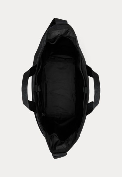 Must avatud käekott kahe sangaga ja avara voodrita sisemusega, mille taustaks on hele ühtlane pind.