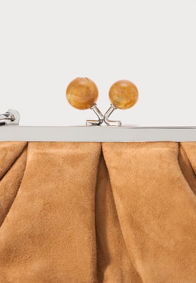 Hnědá semišová kabelka s nařaseným designem, stříbrným rámem a dvěma odpovídajícími kulatými sponami. Měkká textura a hladký povrch.