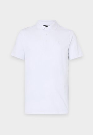 Valge polo särk, mis on valmistatud pehmest puuvillast, klassikalise krae, kolme nupuga ja väikese, jõhvikas kujulise logoga rinnal.