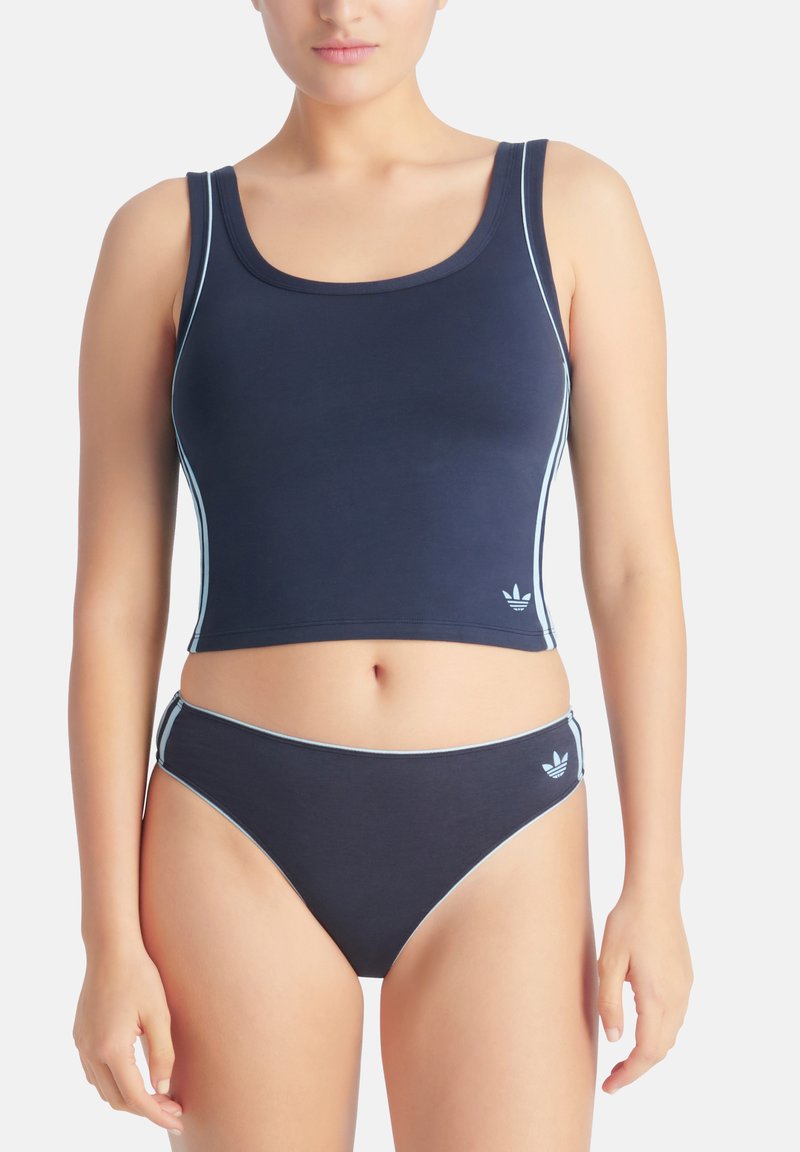 Námořnicky modrý krátký top s světle modrým lemováním a odpovídajícími spodními kalhotkami plavek. Na obou kusech je logo Adidas. Hladká, pružná tkanina.