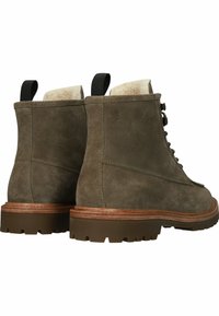 Bruna mocka ankelstövlar med en texturerad yta, med en brun gummisula, snörning framtill och dragflik bak.