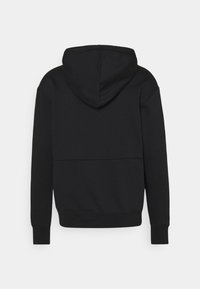 Sudadera negra de tela suave, con una gran capucha, mangas largas y un diseño simple con un detalle de costura en la parte posterior.