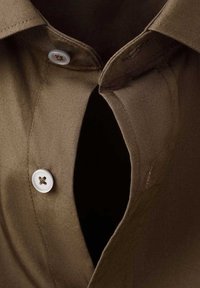 Camisa marrón con cierre de botones y una apertura de cuello ancha y distintiva. Textura suave, con botones blancos que ofrecen contraste.