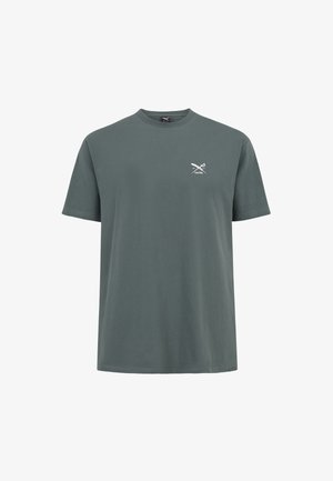 Dunkelgrünes Baumwoll-T-Shirt mit rundem Halsausschnitt, kurzen Ärmeln und einem kleinen weißen Grafikdesign mit gekreuzten Scheren auf der Brust.