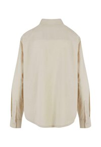 Beige langermet skjorte med krage, knappmansjetter og rett kant. Laget av et mykt, strukturert, lett stoff.