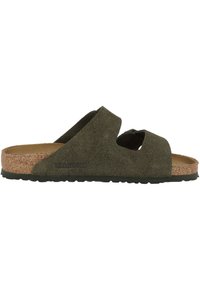 Grüne Wildleder-Sandale mit Korkfußbett, offenes Design mit überkreuzten Riemen und einer strukturierten Gummisohle für besseren Halt.
