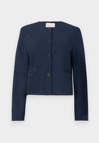 Veste col montant à manches longues bleu marine, sans col, avec quatre boutons noirs et deux poches latérales fentes, coupe ajustée.