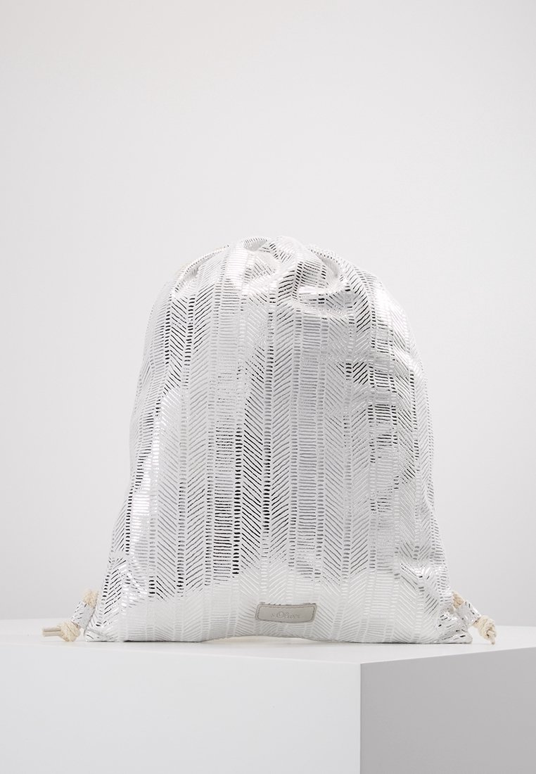 Sac blanc à cordon avec un motif en chevrons brillant et texturé reposant sur une surface blanche sur un fond uni.