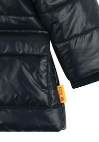 Zwarte pufferjack met een glanzende afwerking, voorzien van horizontale stiksels, een gele merklabel en ribgebreide manchetten voor een comfortabele pasvorm.