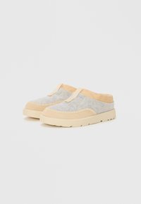 Grå slip-on sko med beige semsket skinndetaljer og søm. Gummisåle med teksturert detaljering, med en løkke på hælen for enkel påkledning.
